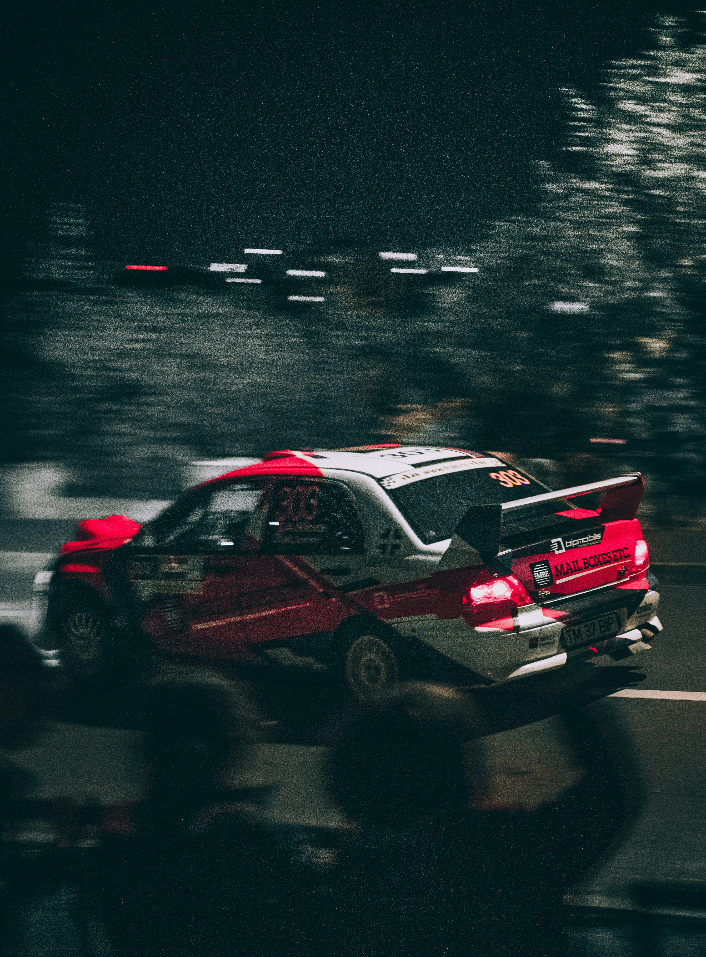 red and white racing car on road during night time